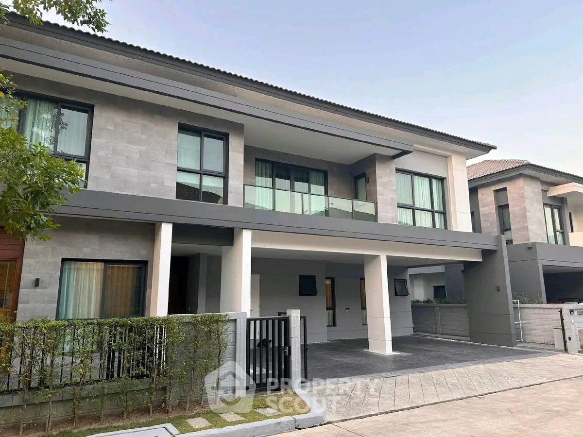 Modern two-story house with large windows and driveway in a suburban neighborhood.