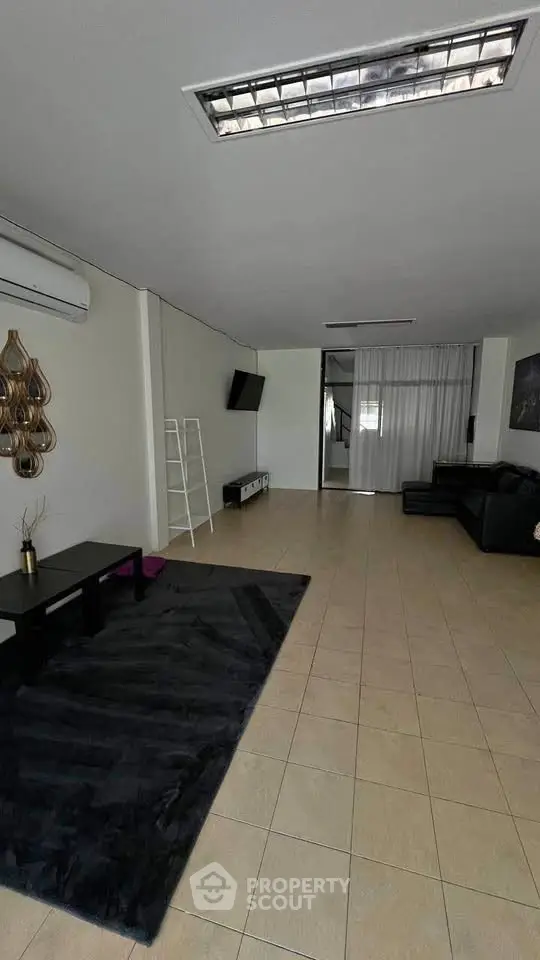 Spacious living room with modern decor and tiled flooring