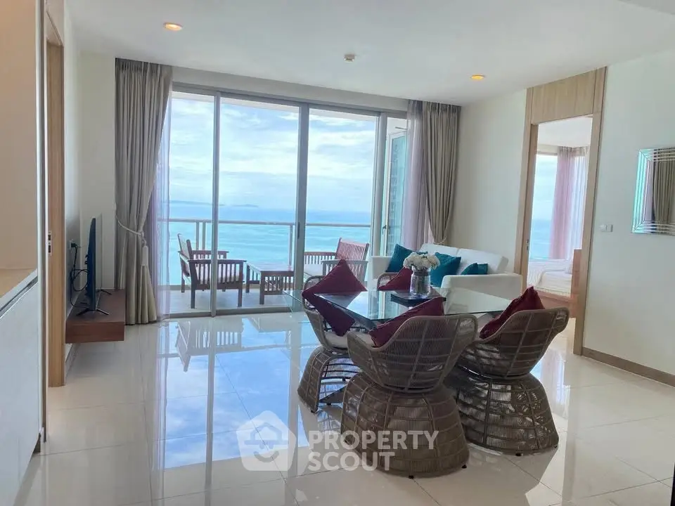 Stunning ocean-view living room with modern decor and spacious balcony access.