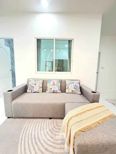 Modern living room with stylish gray sofa and colorful cushions, perfect for cozy relaxation.
