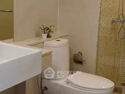 Modern bathroom with sleek fixtures and a glass shower enclosure.