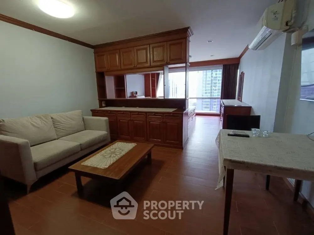 Spacious living room with wooden cabinetry and city view, perfect for modern living.