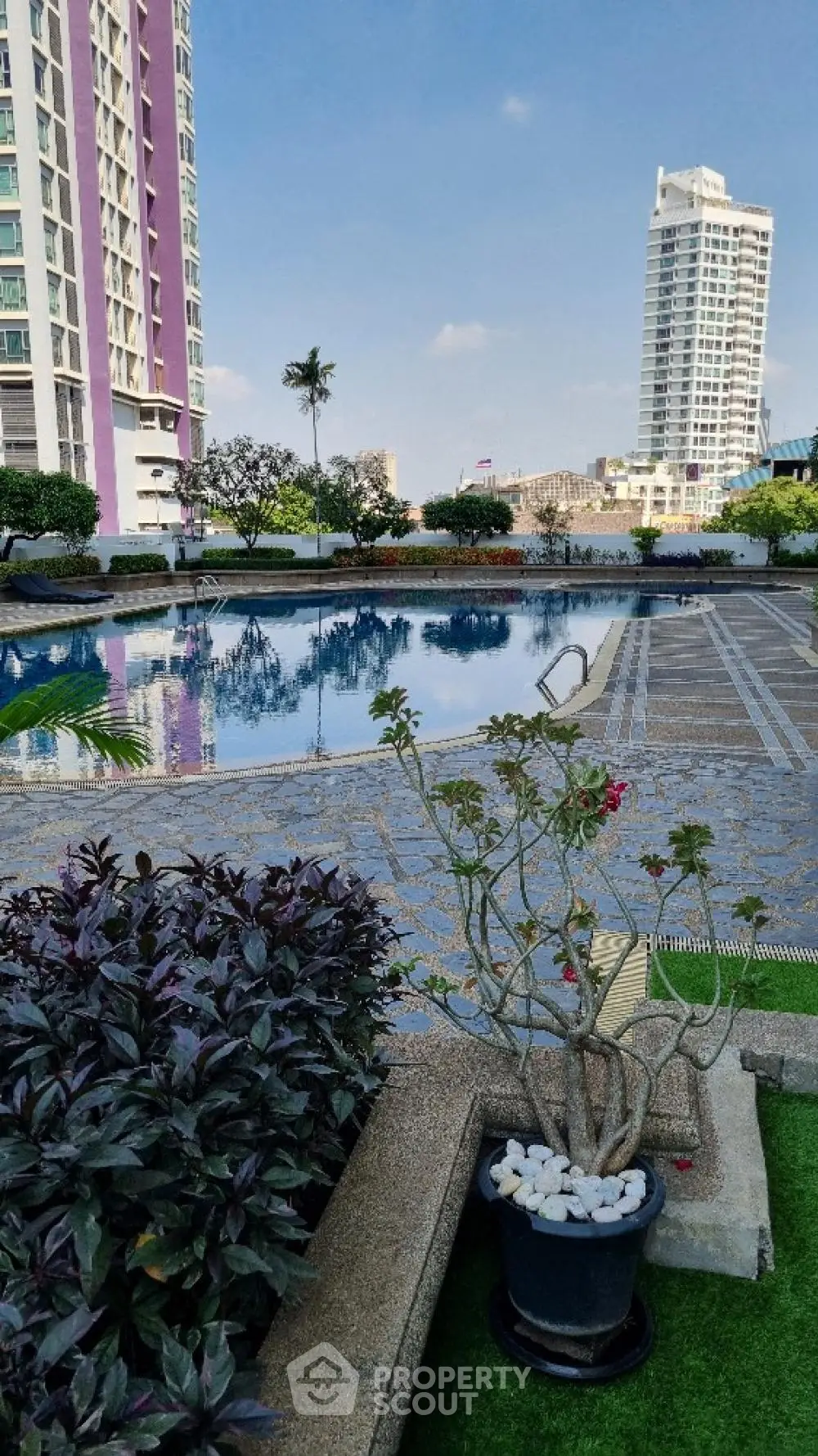 Luxurious high-rise condominium complex with a stunning outdoor pool, lush landscaping, and modern architecture, offering an urban oasis in a prime location.