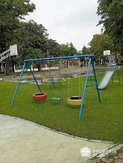 Charming playground with swings and slide in lush green park setting