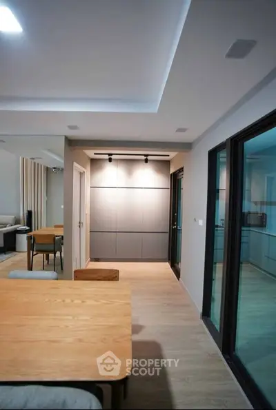 Modern open-plan living area with sleek dining table and stylish lighting, perfect for contemporary living.