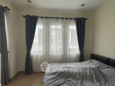 Cozy bedroom with large windows and elegant curtains, perfect for natural light lovers.