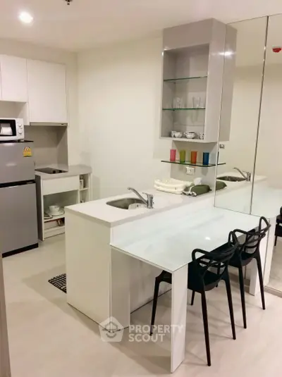 Modern kitchen with sleek design, featuring a compact layout and stylish dining area.