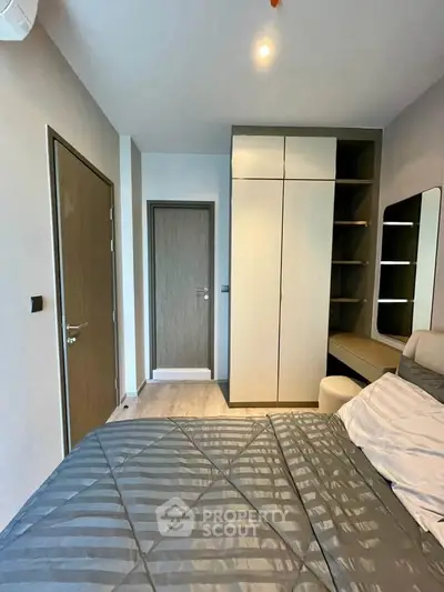 Modern bedroom with sleek wardrobe and cozy bed in stylish apartment.