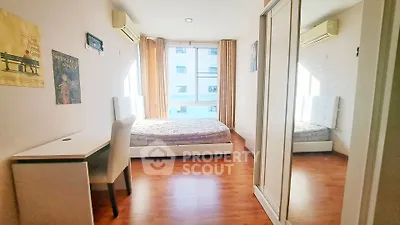 Bright bedroom with mirrored closet and wooden flooring in modern apartment.