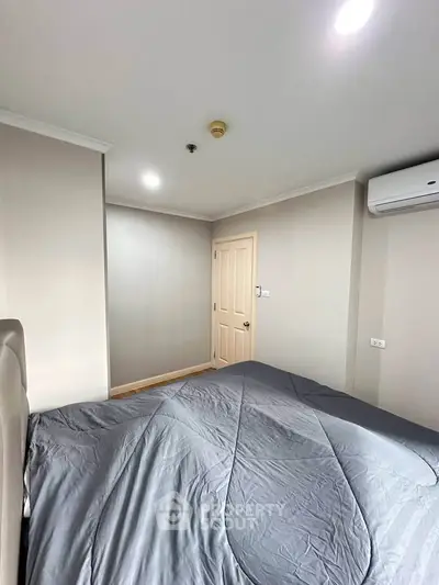 Cozy bedroom with modern air conditioning and neutral decor, perfect for relaxation and comfort.