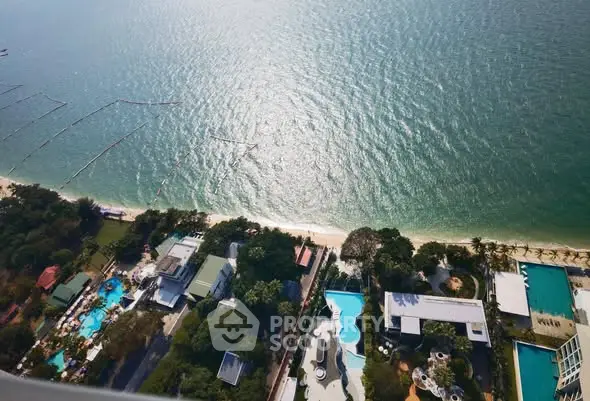 Stunning aerial view of beachfront properties with pools and lush greenery, perfect for luxury living.