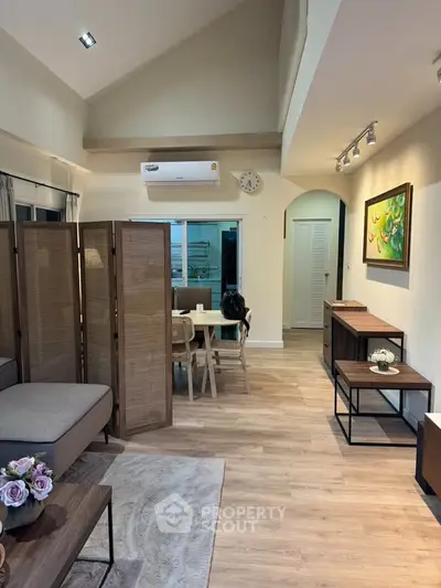 Stylish living room with modern decor and open layout, featuring elegant furniture and ambient lighting.