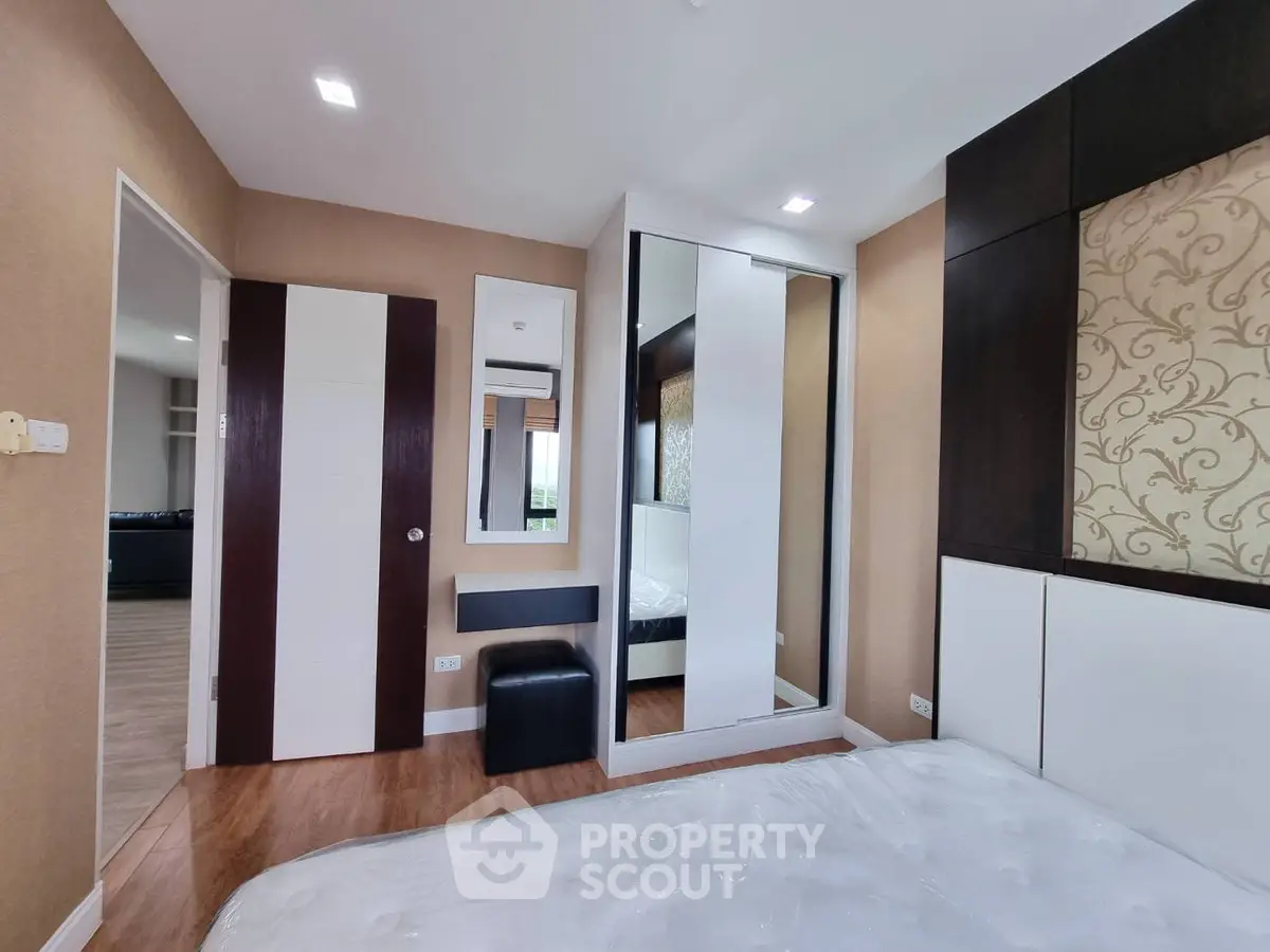 Modern bedroom with stylish decor and mirrored wardrobe