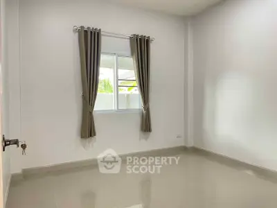 Spacious empty room with large window and elegant curtains, perfect for customization.