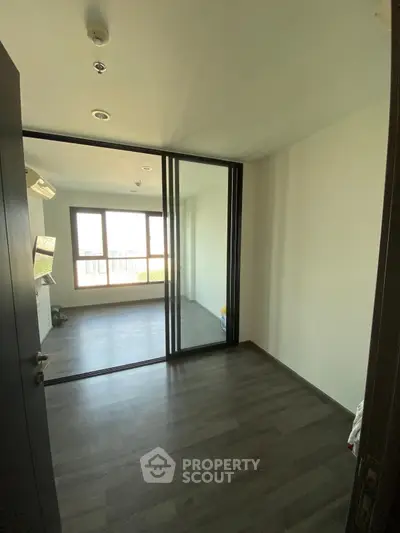 Spacious room with large windows and sliding glass doors, perfect for natural light.