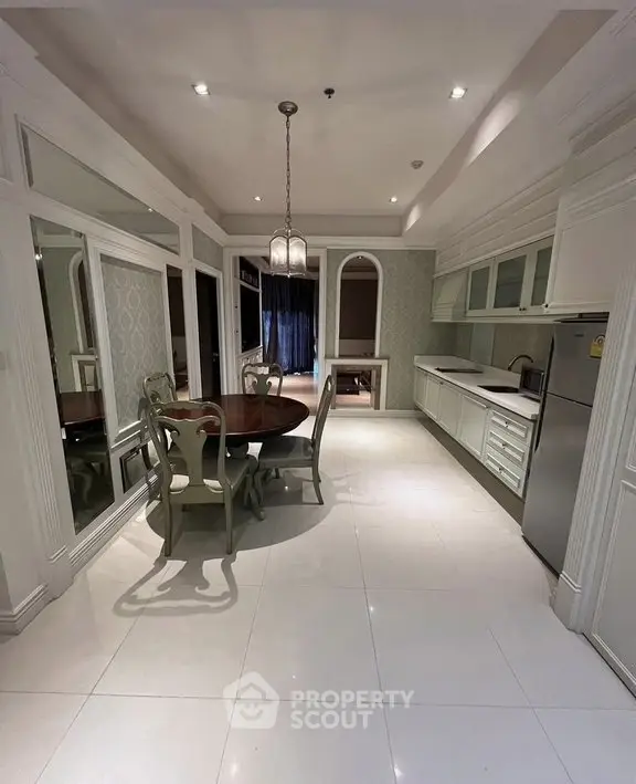 Elegant kitchen with dining area, featuring classic white cabinetry and modern appliances.