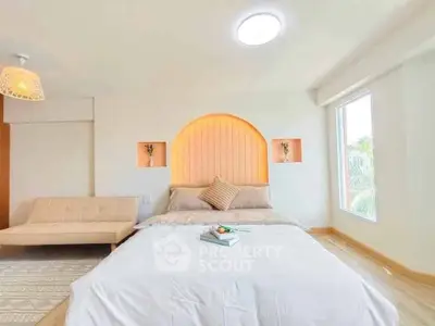 Bright and cozy bedroom with modern decor and large window view.