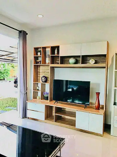 Modern living room with stylish entertainment center and large TV, perfect for relaxation and entertainment.