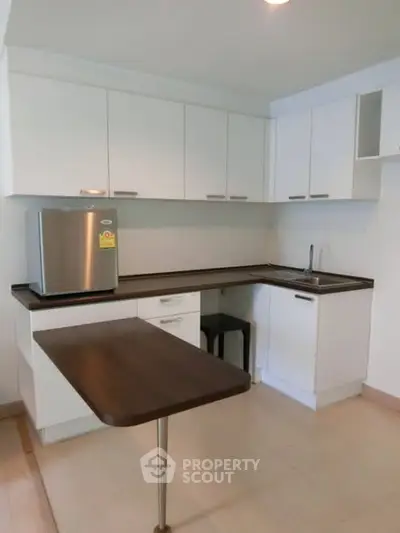 Modern kitchen with sleek white cabinets and compact design