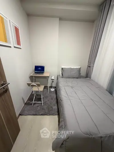 Cozy minimalist bedroom with modern decor and small workspace, perfect for urban living.