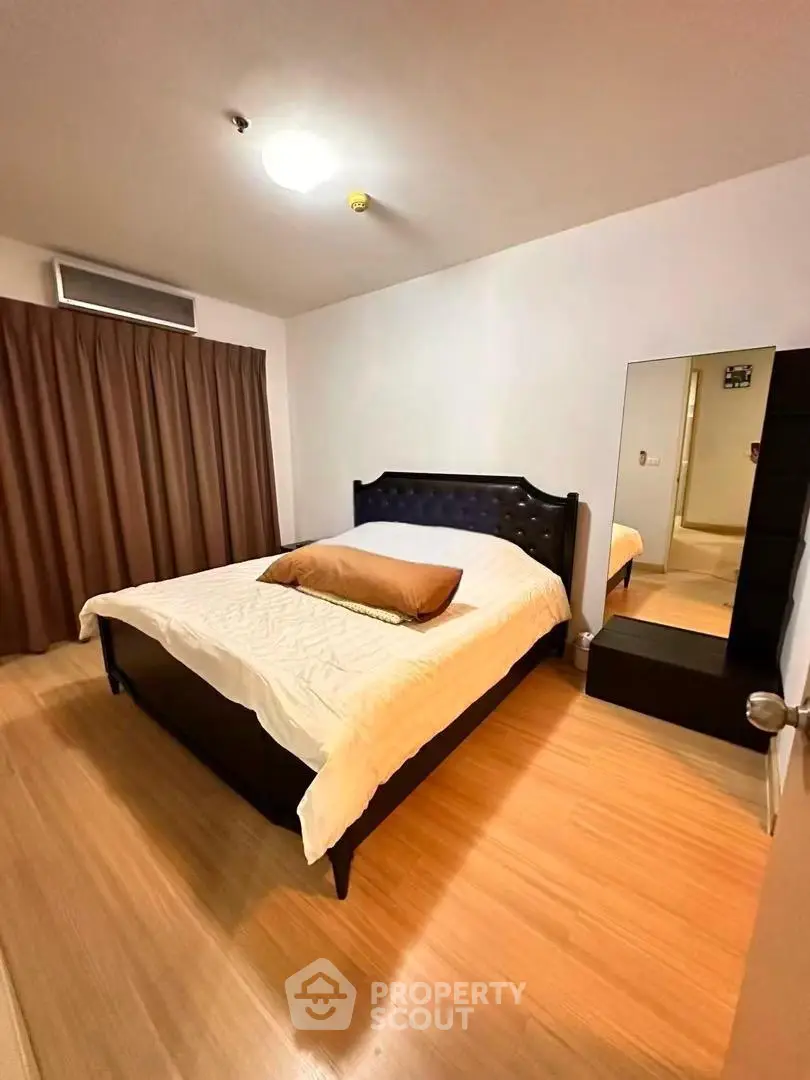 Spacious bedroom with elegant bed and wooden flooring in modern apartment