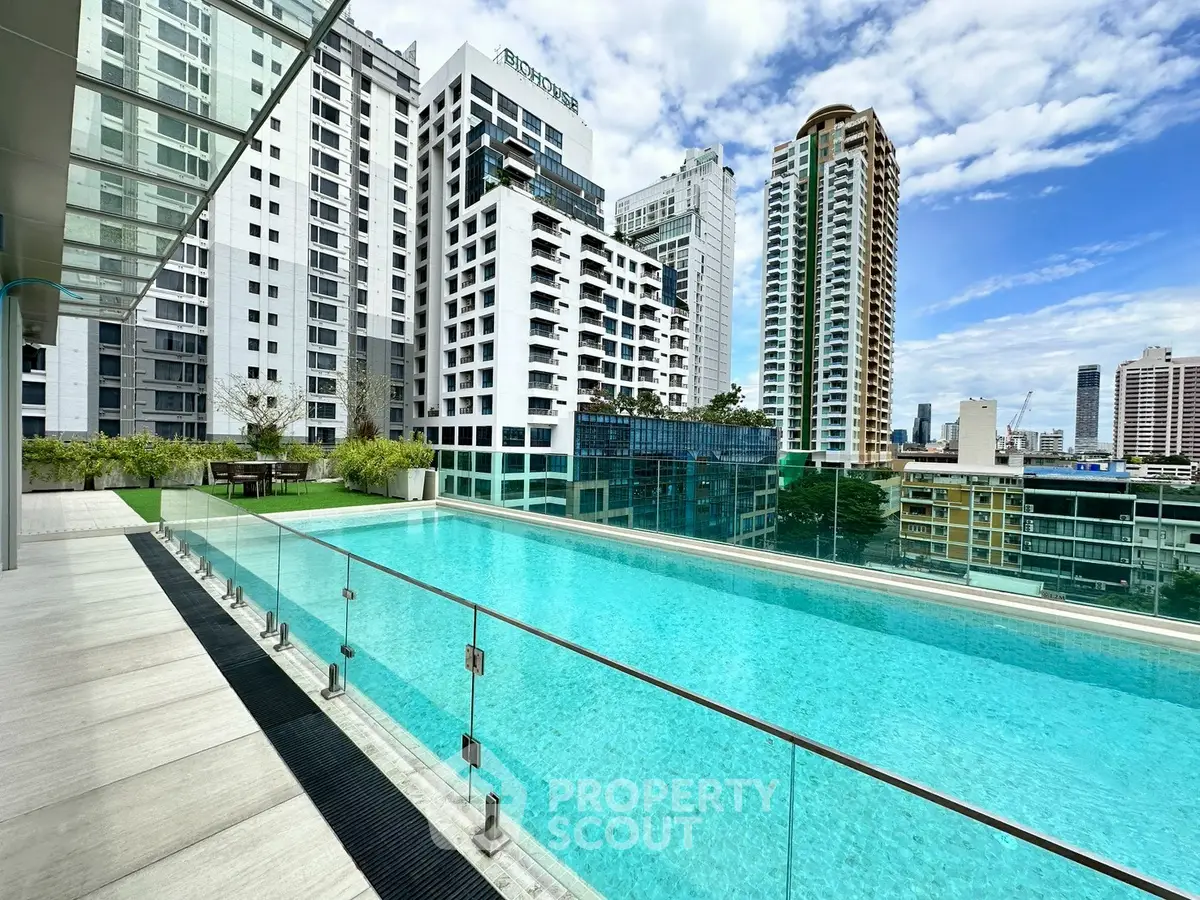 Luxurious rooftop pool with stunning city skyline views in modern high-rise building.