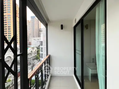 Modern apartment balcony with city view and glass sliding doors