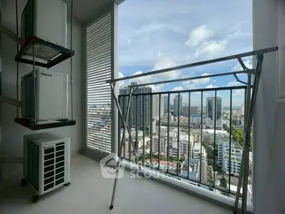 High-rise apartment balcony with stunning cityscape view and laundry area.