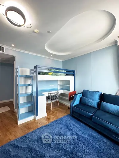 Modern blue-themed living room with loft bed and cozy seating area