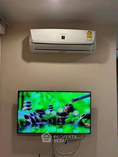 Modern living room with wall-mounted air conditioner and flat-screen TV for comfort and entertainment.