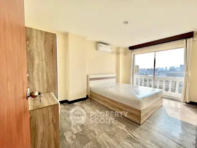 Spacious bedroom with city view and modern furnishings in high-rise apartment
