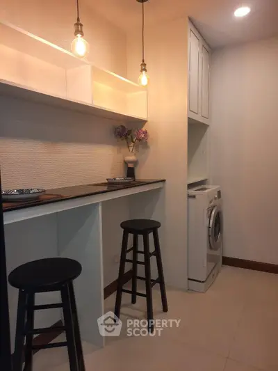 Cozy kitchen corner with washing machine and stylish bar stools