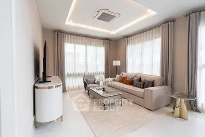 Elegant living room with modern decor, featuring a cozy sofa, stylish coffee table, and large windows with sheer curtains.