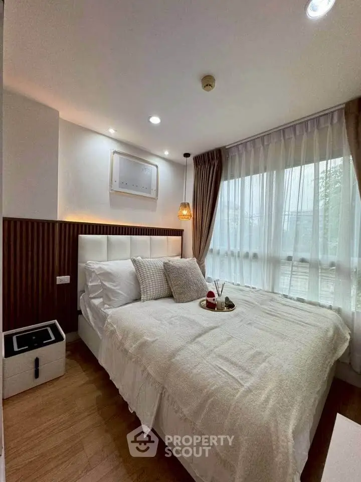 Cozy bedroom with elegant decor and large window for natural light.