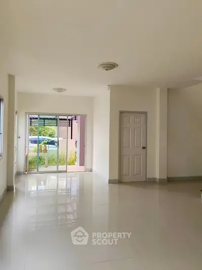 Spacious and bright living room with large windows and glossy floors