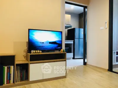 Modern living room with TV and open view to kitchen area