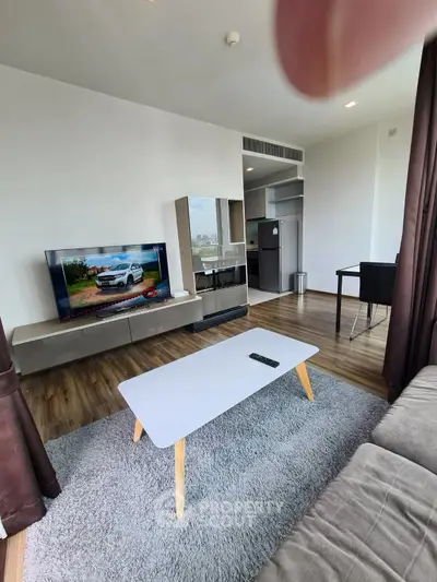 Modern living room with sleek furniture and city view, featuring a stylish TV setup and cozy ambiance.