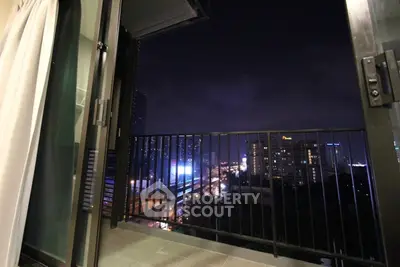 Stunning city view from a modern apartment balcony at night, showcasing urban skyline and vibrant lights.