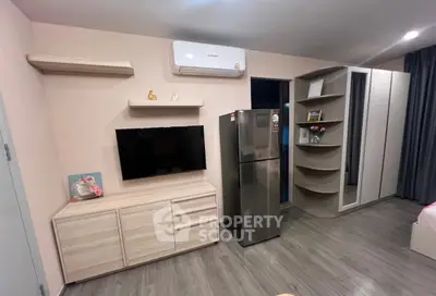Modern bedroom with sleek storage, TV, and air conditioning in stylish apartment.
