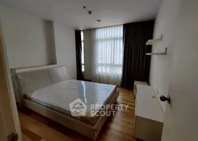 Spacious bedroom with large window and modern furnishings