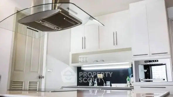 Modern kitchen with sleek white cabinets and built-in oven