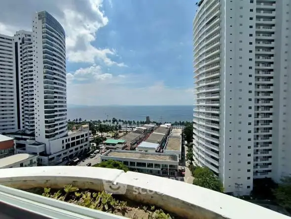 Stunning ocean view from high-rise balcony with modern buildings