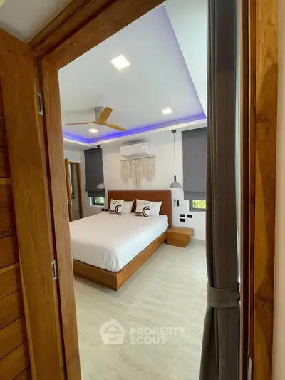 Modern bedroom with stylish decor and ambient lighting, featuring a cozy bed and wooden accents.