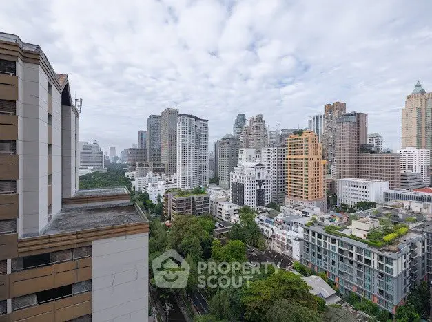 Stunning cityscape view from a high-rise building showcasing urban skyline and lush greenery.
