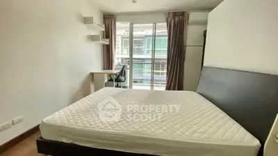 Modern bedroom with large window and study desk, offering natural light and a cozy atmosphere.
