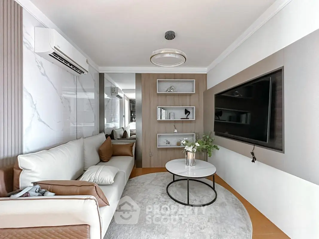 Modern living room with sleek design, featuring a comfortable sofa, wall-mounted TV, and stylish decor.
