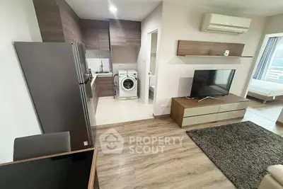 Modern apartment interior with open kitchen, living area, and bedroom view.