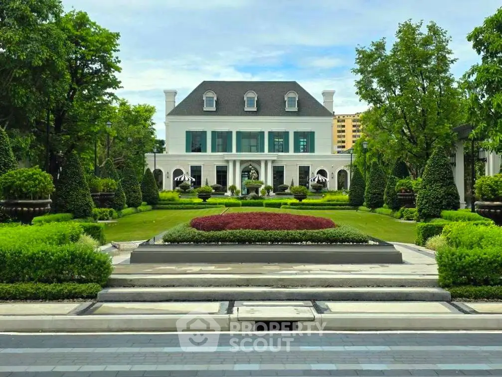 Luxurious mansion with manicured garden and grand entrance