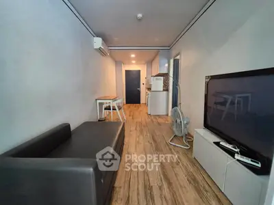 Modern living room with sleek furniture and wooden flooring in a cozy apartment.