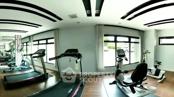 Modern gym with state-of-the-art equipment and large windows for natural light.